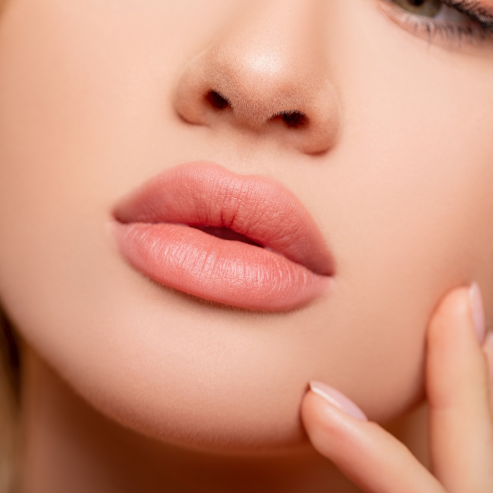 Beautiful lips Close-up. Makeup. Lip matte lipstick. Sexy lips. Part of face, young woman close up. perfect plump lips bodily lipstick. peach color of lipstick on large lips. Perfect makeup