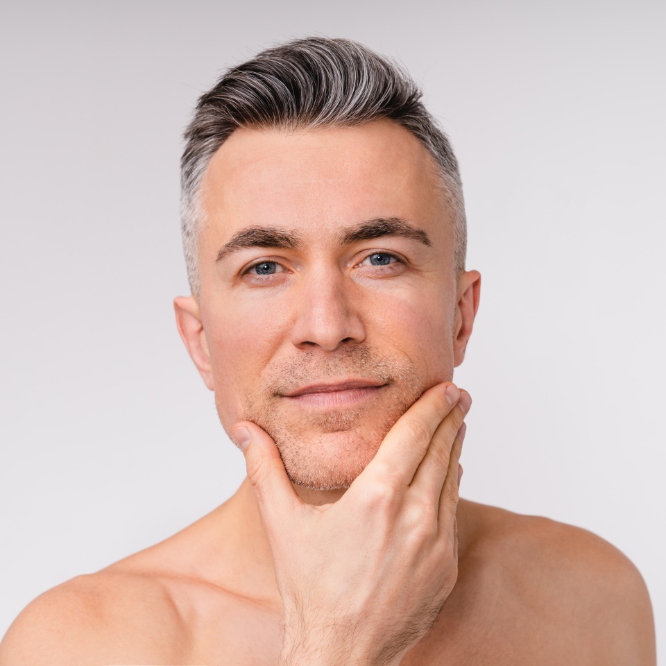 Sexy caucasian man looking into a camera shirtless isolated over white background