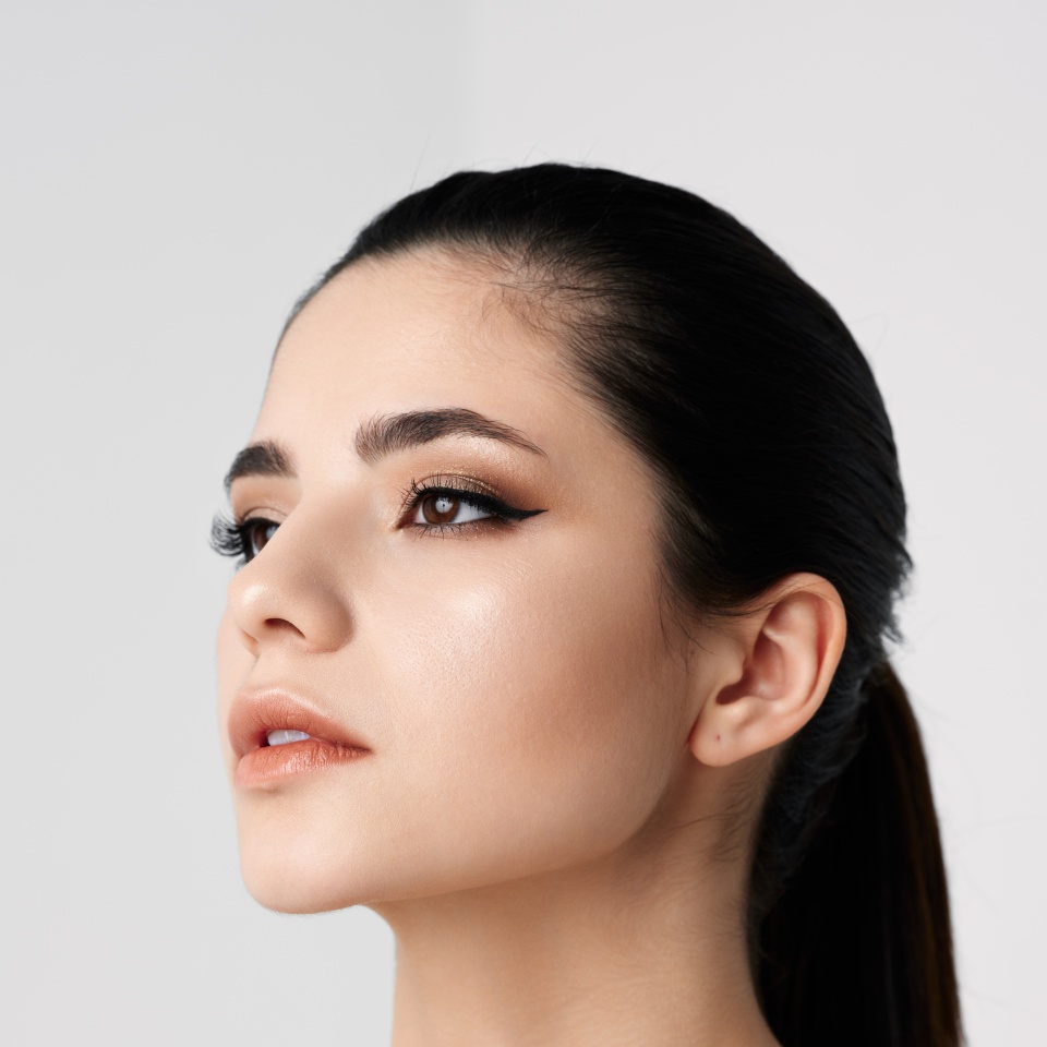 pretty woman with makeup on face bared shoulders close-up side view