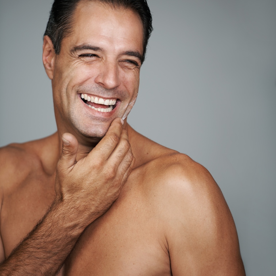 Wish I knew where the fountain of youth was. Studio portrait of a handsome mature man applying moisturizer to his skin.
