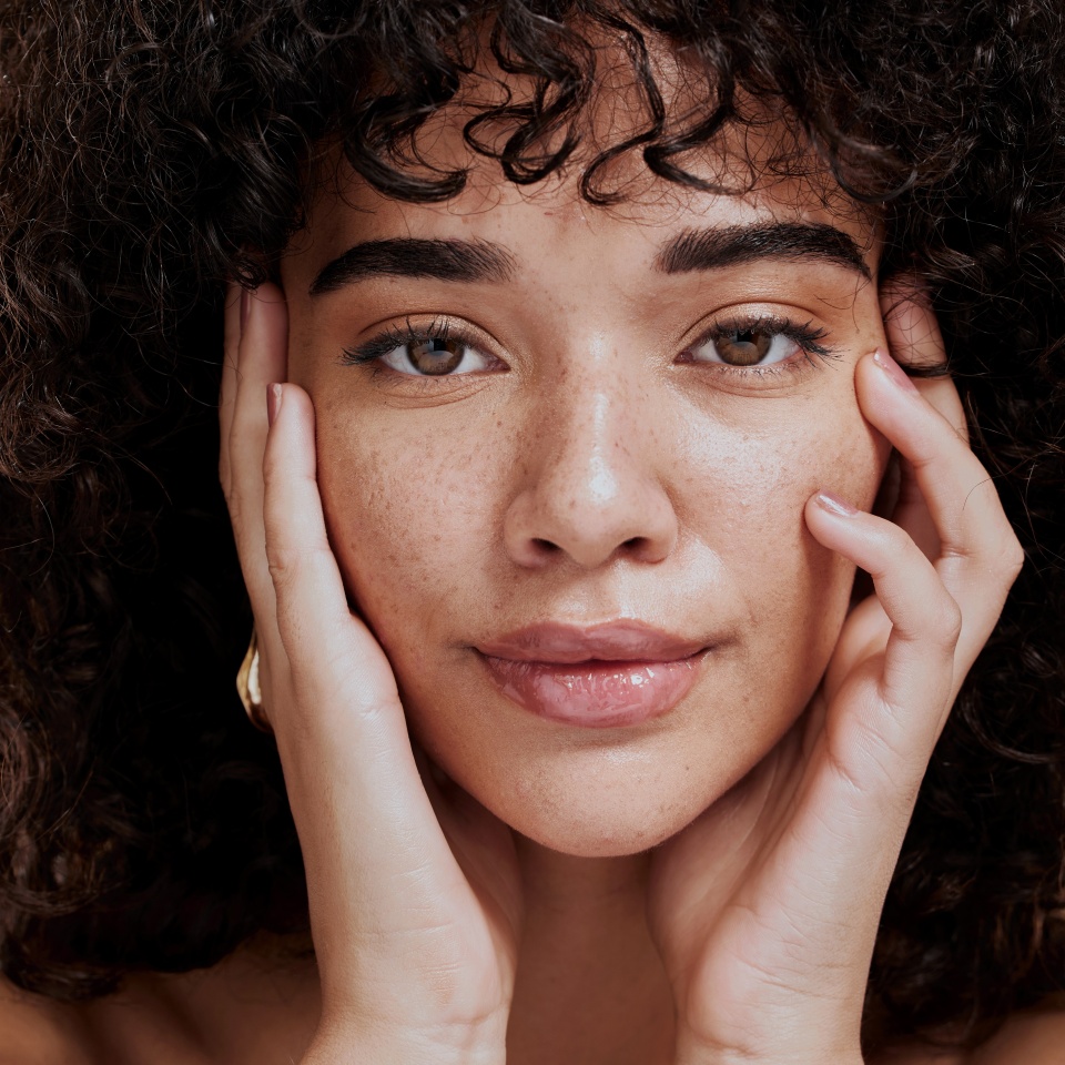 Beauty, portrait and natural face of black woman with healthy freckle skin texture touch. Aesthetic, facial and skincare cosmetic model girl touching cheeks for self love and wellness.