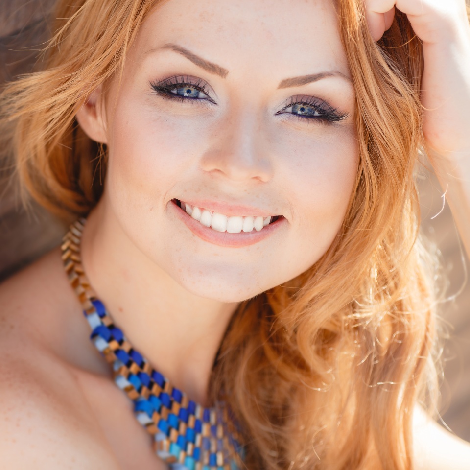 Portrait Of Young Smiling Beautiful Woman. Stunning young woman posing outdoor over brick wall. Portrait of a beautiful woman
