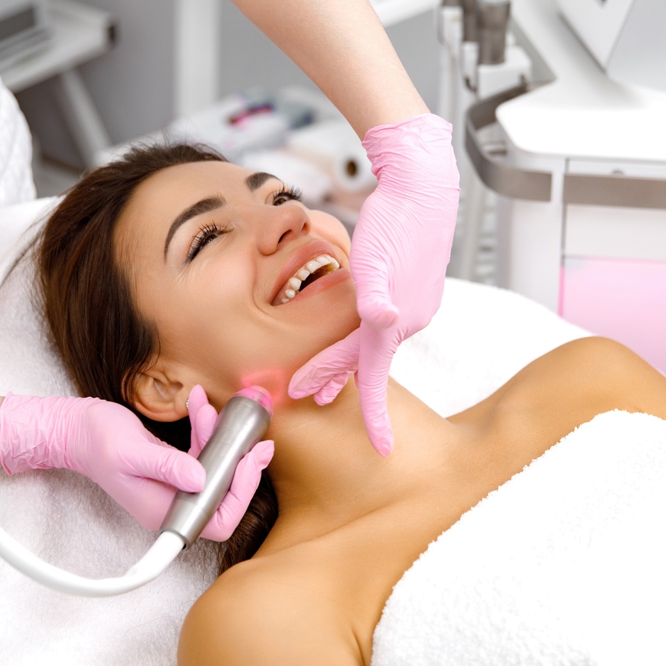 Skin care service,Facial treatment,Cosmetology service,Healthy skin,Hydro infusion,Hydro-dermabrasion,esthetic procedure,cosmetologist is performing a procedure on the face of a young, smiling girl