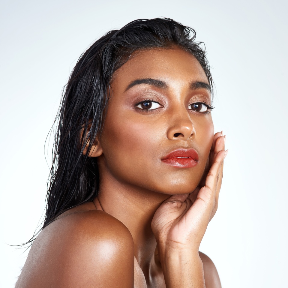 Beauty, studio and portrait of Indian woman with makeup and skincare in mockup space. Model, face and girl with confidence from healthy self care and pride from cosmetics in white background