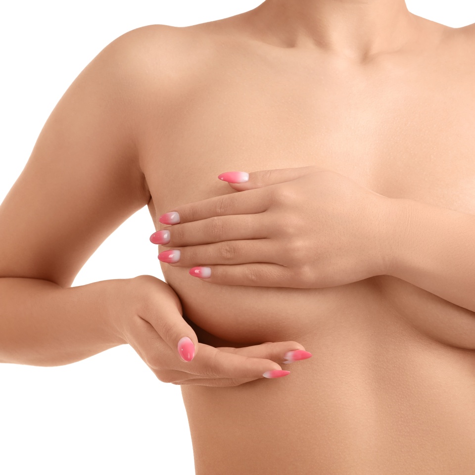 Naked young woman covering her breasts on white background, closeup