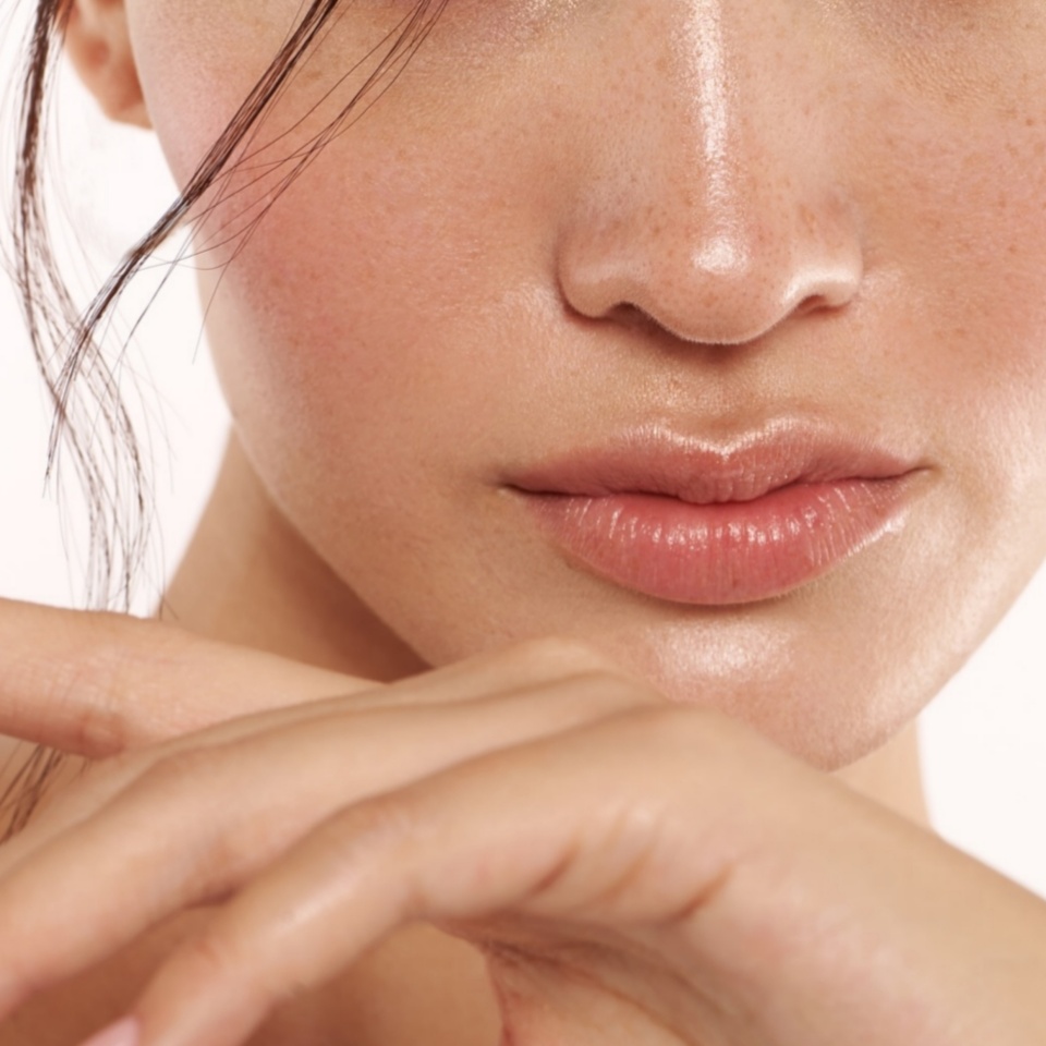 Close up of beautiful young woman's face with clear clear skin and beautiful lips with makeup for skin and body care _ Body and skin care