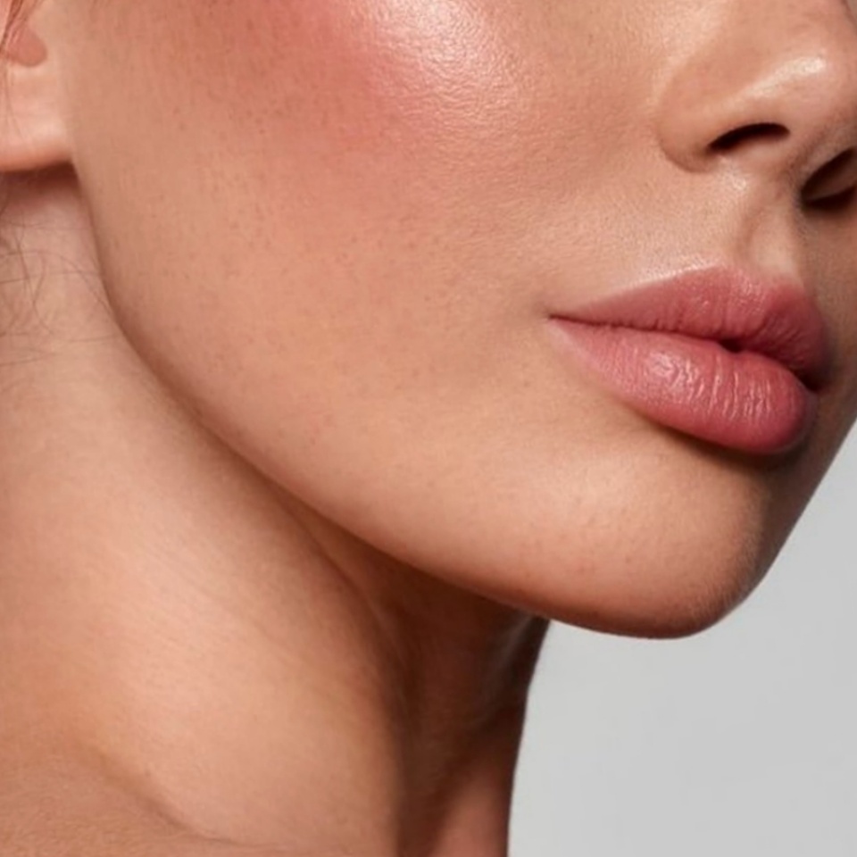 Close up of beautiful young woman's face with makeup, fresh and smooth skin and lipstick _ Skin and body care