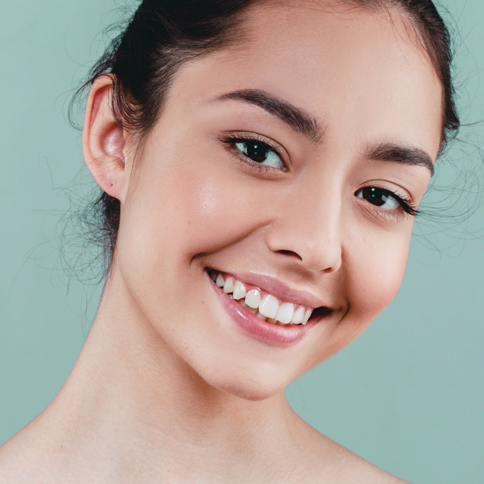 Beauty Woman face Portrait. Beautiful model Girl with Perfect Fresh Clean Skin color lips purple red. Healthy teeth smile Youth and Skin Care Concept. I