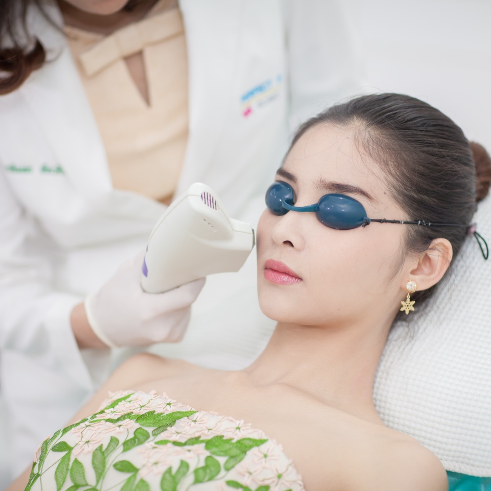 Face Care. Facial Laser Hair Removal. Beautician Giving Laser Epilation Treatment To Young Woman Face At Beauty Clinic. Body Care. Hairless Smooth And Soft Skin. Asian girl. Health And Beauty Concept.
