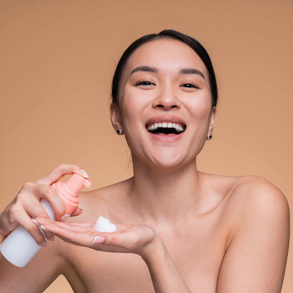 A woman holding a bottle of lotion.